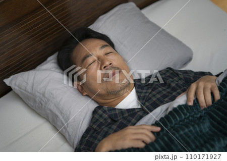 ベッドで睡眠中の50代半ばの男性の寝顔 ベッドで睡眠中の50代半ばの男性の寝顔 110171927