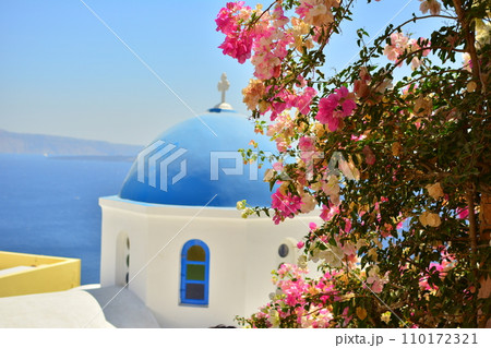 ギリシャ、サントリーニ島の青い海と白い街並み、ピンク色の花 ギリシャ、サントリーニ島の青い海と白い街並み、ピンク色の花 110172321