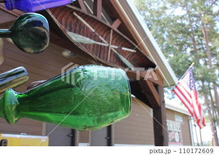 Vintage Recycled Bottles on Metal Rack With American Flag in Background Vintage Recycled Bottles on Metal Rack With American Flag in Background 110172609