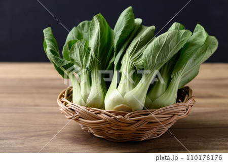 Bok choy or Pak choi (Chinese cabbage) in basket on wooden table with black background Bok choy or Pak choi (Chinese cabbage) in basket on wooden table with black background 110178176