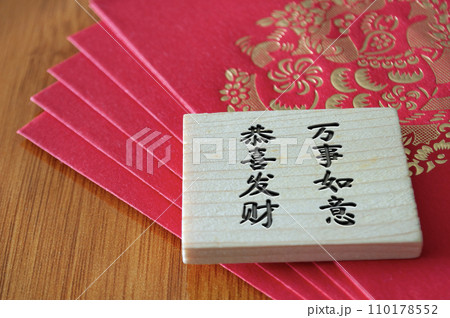 Close up view of Chinese New Year red packets with Chinese New Year wishes on wooden block 110178552
