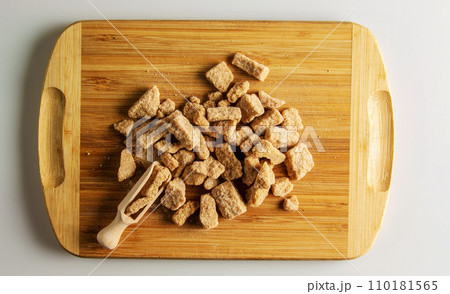 Background of brown unrefined sugar. Healthy food concept. Cane sugar on a wooden cutting board background 110181565