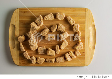 Background of brown unrefined sugar. Healthy food concept. Cane sugar on a wooden cutting board background 110181567