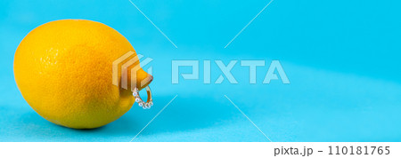 Intimate piercing. Minimal piercing concept. Lemon with inserted iron decoration, piercing Intimate piercing. Minimal piercing concept. Lemon with inserted iron decoration, piercing 110181765