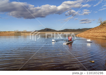 Senior male rower is rowing a coastal rowing shell - Horsetooth Reservoir in fall or winter scenery in northern Colorado. Senior male rower is rowing a coastal rowing shell - Horsetooth Reservoir in fall or winter scenery in northern Colorado. 110183296