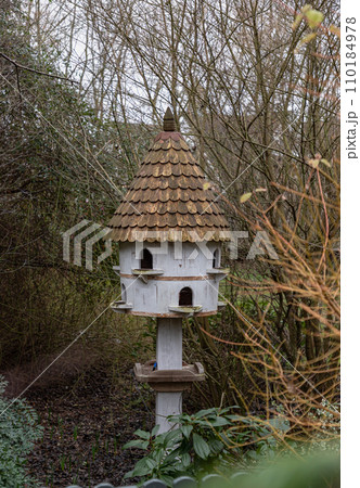 A dovecote shelter for birds and doves pigeons with multiple entrances and a pointed roof on a wooden post. A dovecote shelter for birds and doves pigeons with multiple entrances and a pointed roof on a wooden post. 110184978