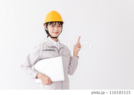 ノートパソコンを持つ作業服の女性　指差し 110185115