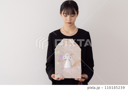 骨壺を持つ若い女性 110185239