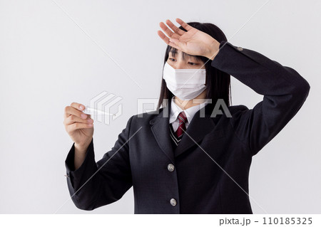 受験日へ向けマスクをして健康に気を遣う女子高生　体温計 110185325