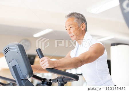 パーソナルジム　エアロバイクで運動をするシニア男性 110185482