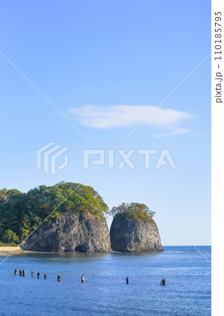 北海道網走市の二ツ岩と、朝日に照らされ海に浸かって釣りをする人々 110185795