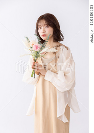 ドライフラワーの花束を持つワンピースの女性 110186205