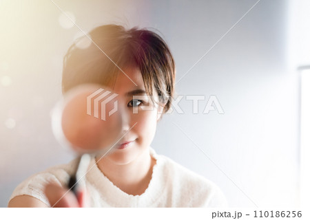 虫眼鏡で覗く女性 110186256