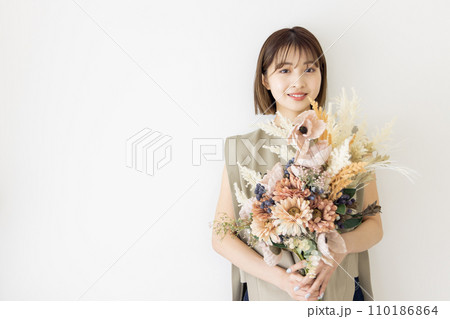 ドライフラワーの花束を持つワンピースの女性 110186864