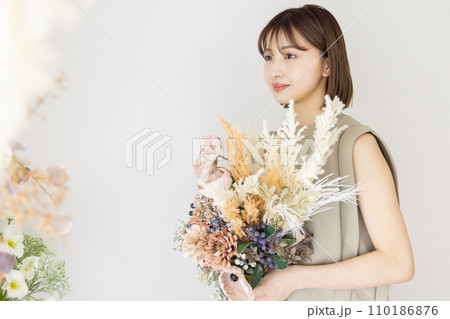 ドライフラワーの花束を持つワンピースの女性 110186876