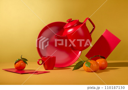 Over yellow background, a tea set in red color decorated with tangerines and few red envelopes. Chinese people consider traditional New Year to be the biggest holiday Over yellow background, a tea set in red color decorated with tangerines and few red envelopes. Chinese people consider traditional New Year to be the biggest holiday 110187130