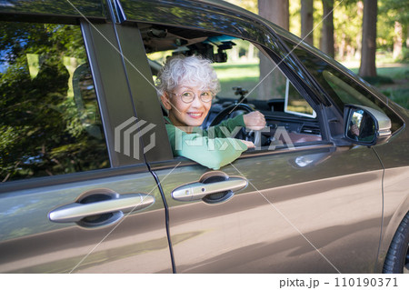 自動車の運転をする高齢者女性 110190371