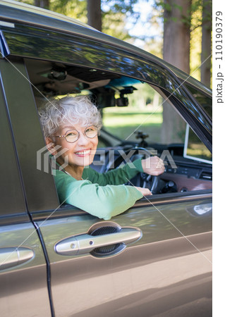 自動車の運転をする高齢者女性 110190379