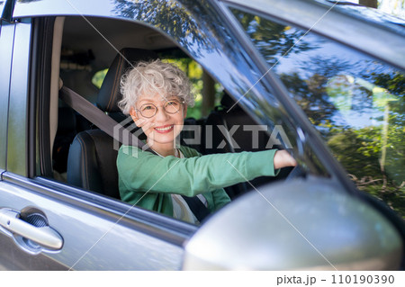 自動車の運転をする高齢者女性 110190390