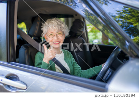 自動車の運転をする高齢者女性 110190394
