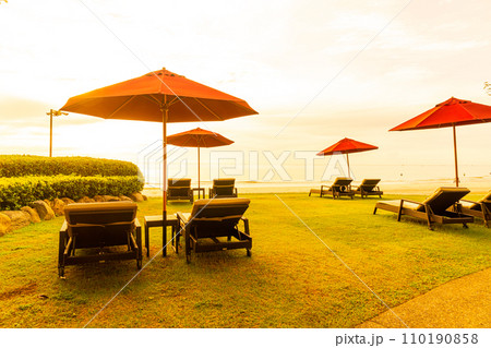 Umbrella with chair with sea beach background and sunrise in morning Umbrella with chair with sea beach background and sunrise in morning 110190858