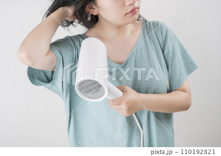 ヘアドライヤーを使う若い女性 110192821
