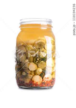 Brussels sprouts, homemade and fermented in a glass jar. Brussels sprouts and green chilies fermented by lactic acid bacteria. Unpasteurized and uncooked they provide probiotics and improve digestion. 110194236