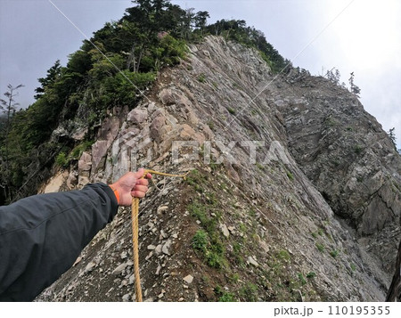 大無間山の崩落地のロープを引く登山者の手 大無間山の崩落地のロープを引く登山者の手 110195355