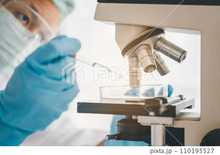 Female researchers are experimenting with pipette dropping a sample into a test tube in an experiment research in laboratory... Female researchers are experimenting with pipette dropping a sample into a test tube in an experiment research in laboratory... 110195527