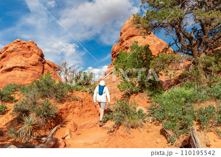 Man Hiking Red Mountains in Arches NP, Moab, Utah 110195542