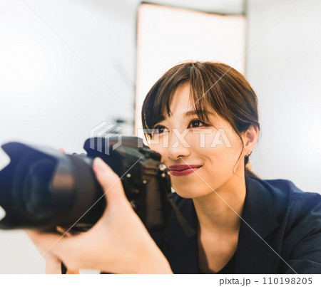 女性のプロフォトグラファーが撮影をしている 女性のプロフォトグラファーが撮影をしている 110198205