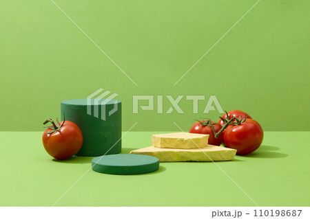 Geometric shaped podiums displayed with natural tomatoes. Green background. Tomatoes do an excellent job at keeping oil production in check Geometric shaped podiums displayed with natural tomatoes. Green background. Tomatoes do an excellent job at keeping oil production in check 110198687