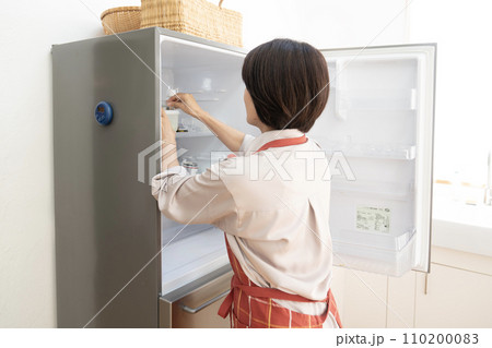 冷蔵庫の片付けをする女性 110200083