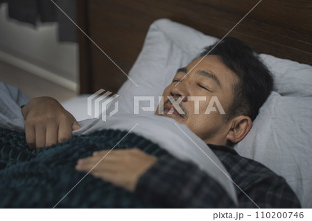 ベッドで睡眠中の50代半ばの男性の寝顔 ベッドで睡眠中の50代半ばの男性の寝顔 110200746