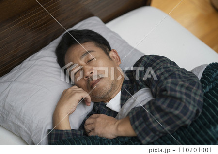 ベッドで睡眠中の50代の男性の寝顔 ベッドで睡眠中の50代の男性の寝顔 110201001