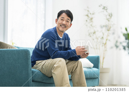 自宅でくつろぐ50代半ばの男性 110201385