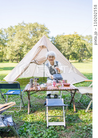 キャンプを楽しむシニア女性 キャンプを楽しむシニア女性 110202558