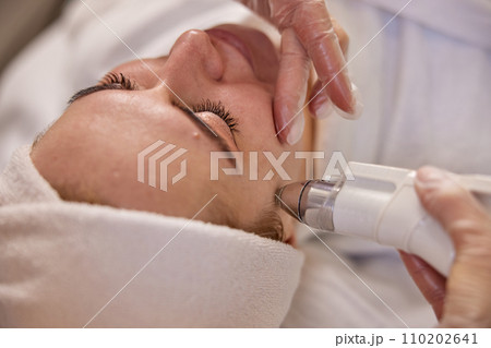 Skin rejuvenation, Aesthetic care, Facial health. In clinical setting, attentive beautician carries out ultrasound treatment focused on facial rejuvenation. 110202641