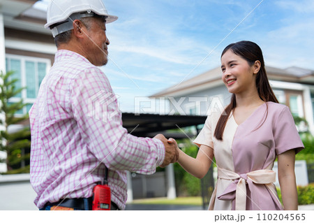 Happy homeowner stand in front of contractor and shake hand, handyman holding clipboard and after checking details before renovations home, house improvement interior, Interior design 110204565