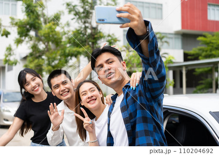 Group of happy young Asian students selfies and videos with smartphones together for vlog and social media on summer vacation. Concept of tourism and travel and road trip, friendship lifestyle. Group of happy young Asian students selfies and videos with smartphones together for vlog and social media on summer vacation. Concept of tourism and travel and road trip, friendship lifestyle. 110204692