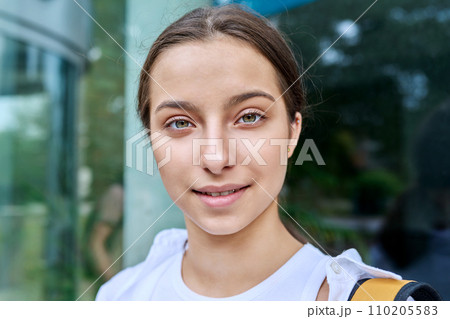 Outdoor portrait smiling high school student girl with backpack 110205583
