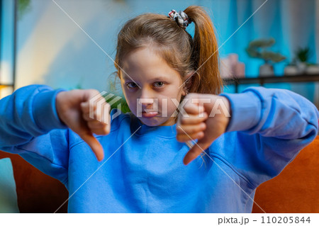 Upset teen girl showing thumbs down, dislike bad work, disapproval, dissatisfied feedback at home 110205844