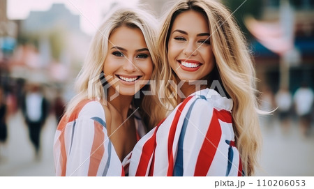 Happy two women with an American flag in the city on the Independence Day holidays of the United States of America. 110206053