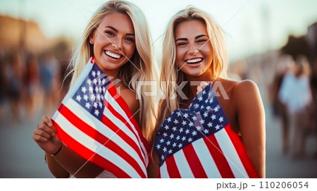 Happy two women with an American flag in the city on the Independence Day holidays of the United States of America. 110206054