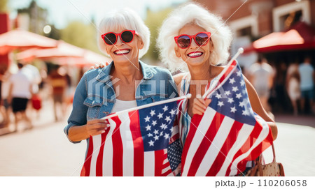 Happy two elderly pensioner women with an American flag on the Independence Day holidays of the United States of America. Happy two elderly pensioner women with an American flag on the Independence Day holidays of the United States of America. 110206058
