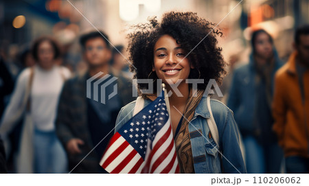 Happy, smiling afro black woman with American flag in the city on the Independence Day holidays of the United States of America. Happy, smiling afro black woman with American flag in the city on the Independence Day holidays of the United States of America. 110206062