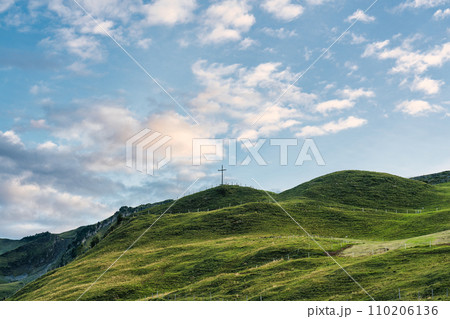 Wooden cross on top of mountain and bright sky in Swiss Alps at Switzerland Wooden cross on top of mountain and bright sky in Swiss Alps at Switzerland 110206136