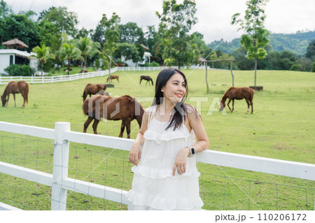 Beautiful asian woman relaxing in horse farm Beautiful asian woman relaxing in horse farm 110206172