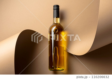 Bottle of white wine on a beige background. 110206632