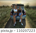 an accident on the road, a car broke down, two beautiful girl models are hitchhiking a car. Showing the thumb up. Problem with the car. Friends waiting for service. In the countryside . High quality 110207223